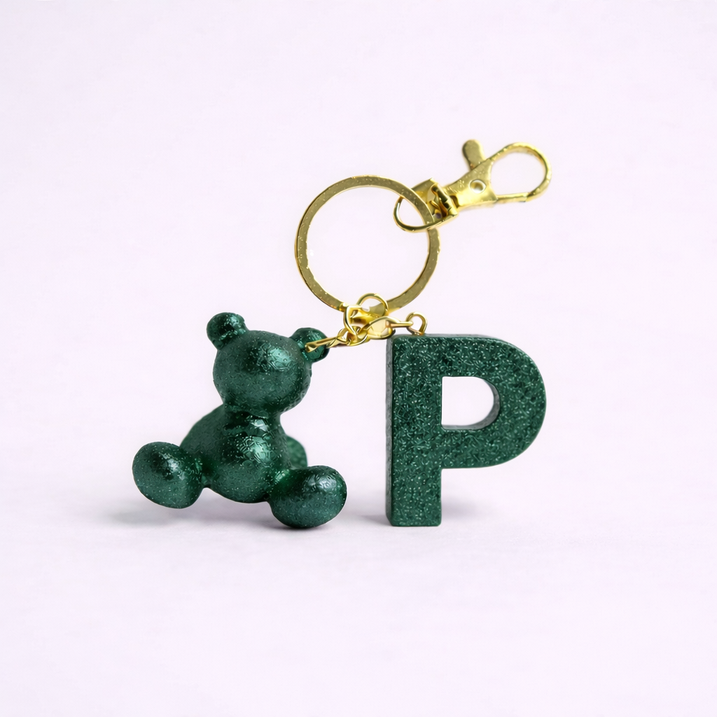 Green handmade resin bear keychain with the letter P on a bag