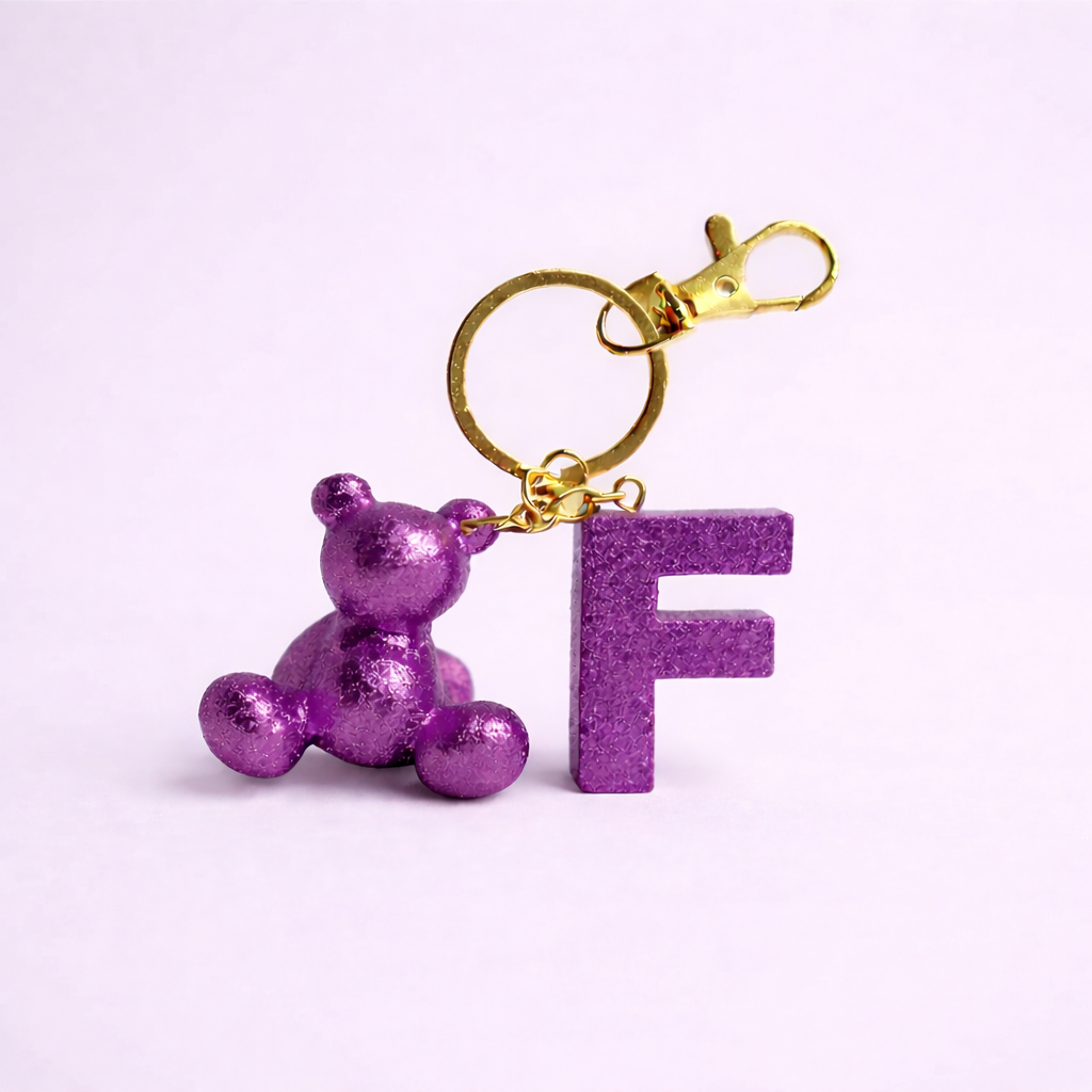 Purple handmade resin bear keychain with the letter F