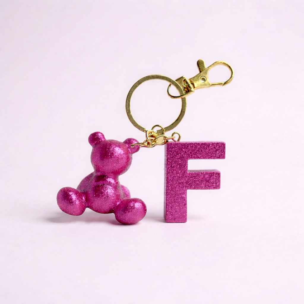Pink handmade resin bear keychain with the letter F