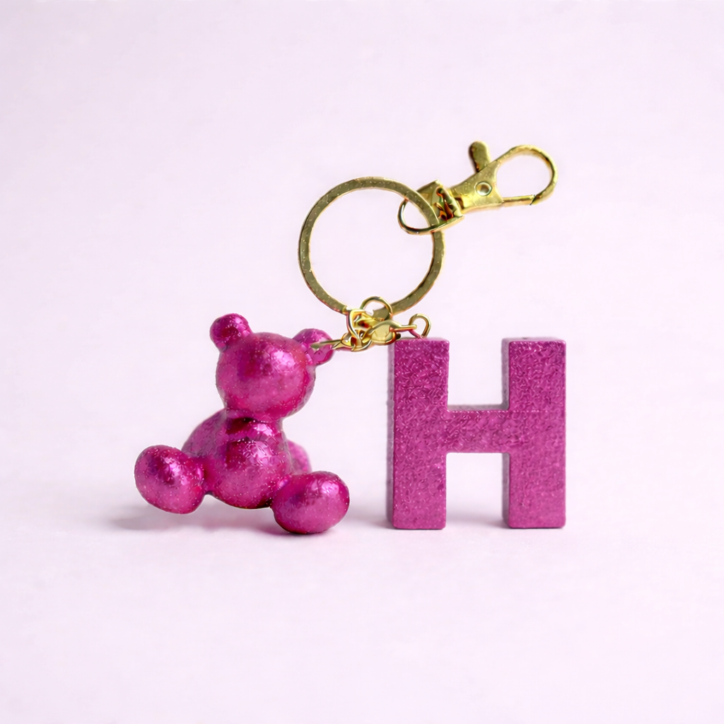 Pink handmade resin bear keychain with the letter H