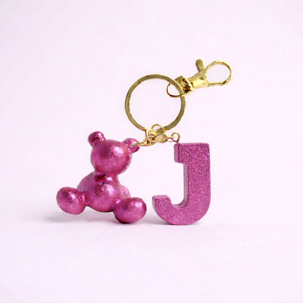 Pink handmade resin bear keychain with the letter J