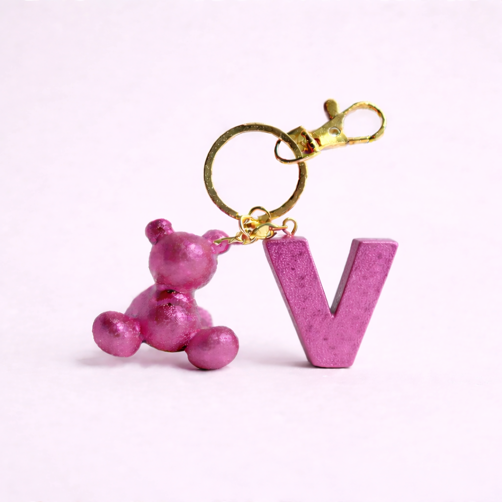 Pink handmade resin bear keychain with the letter V