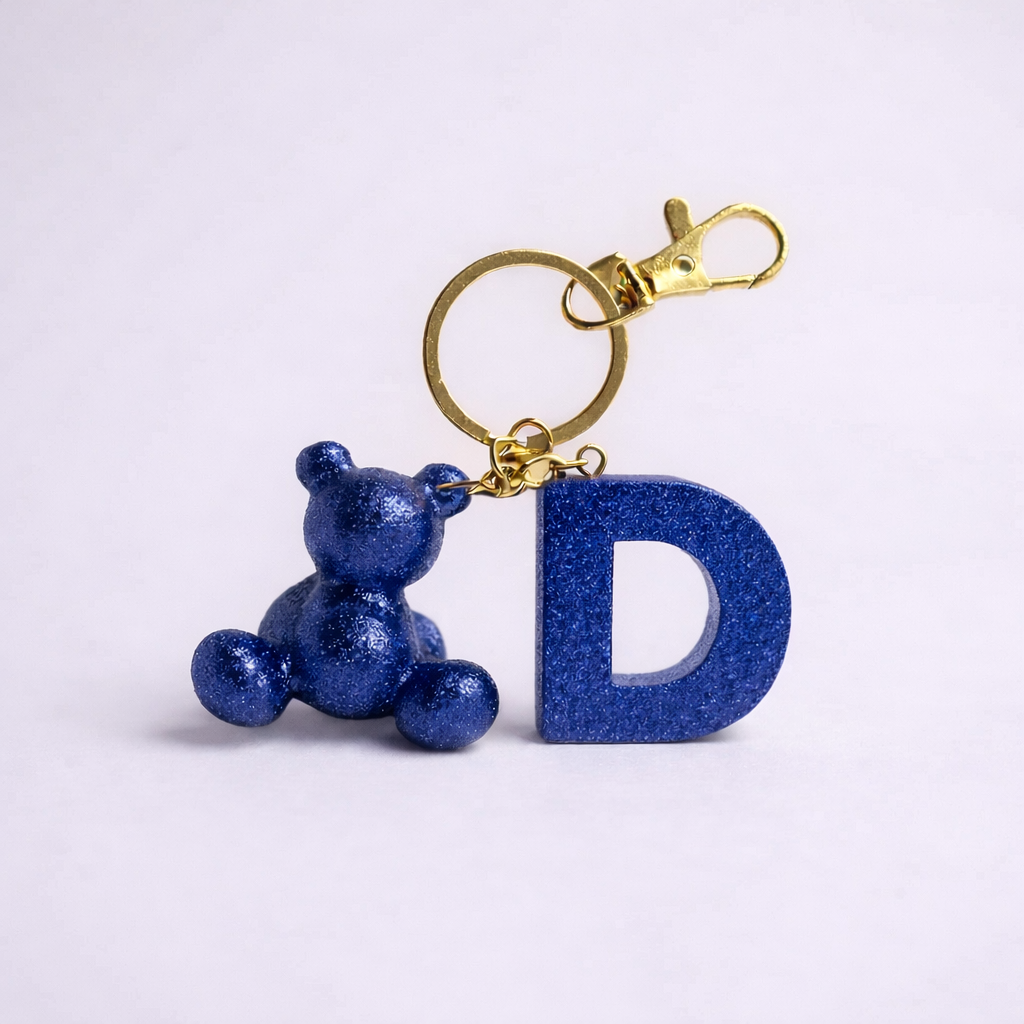 Blue handmade resin bear keychain with the letter D
