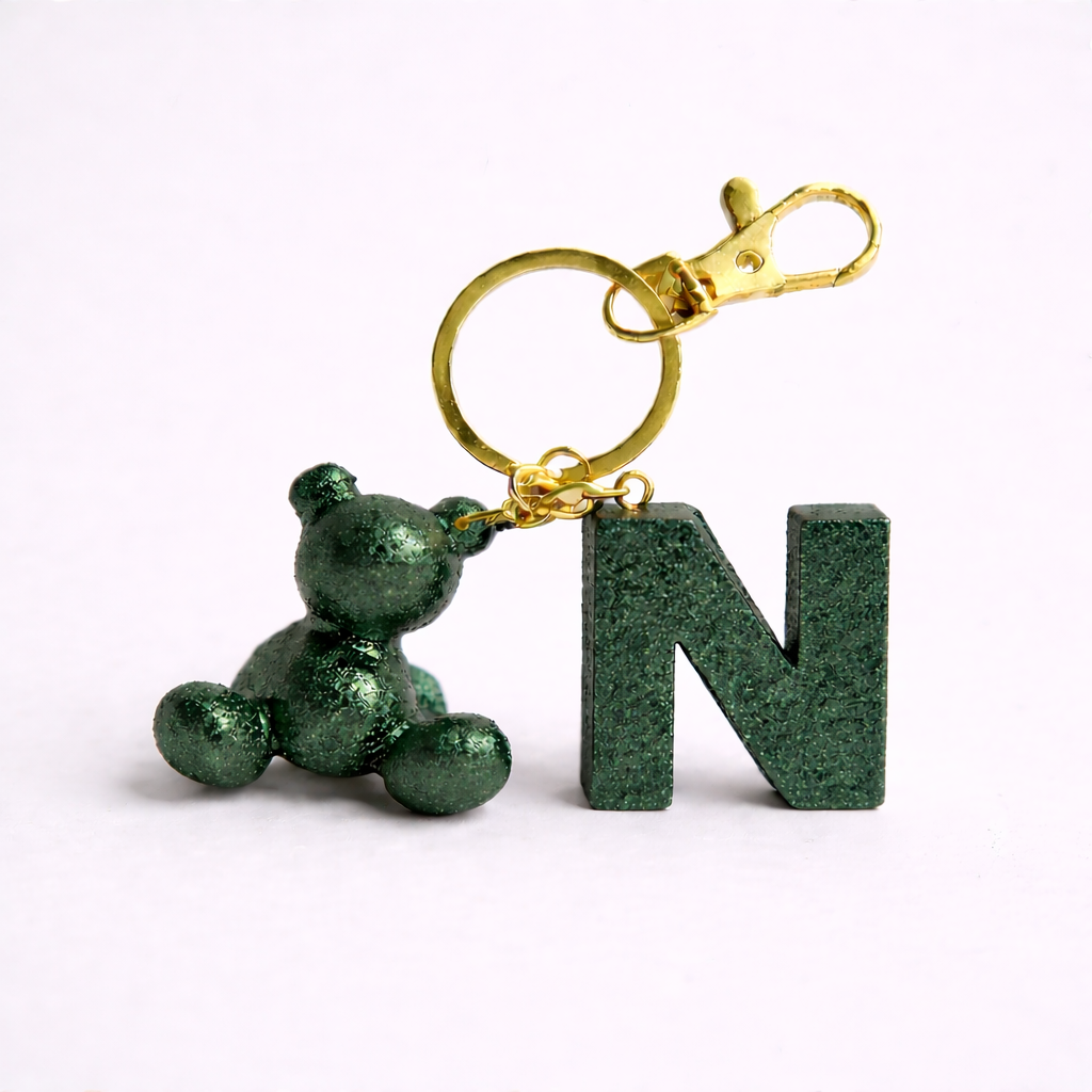 Green handmade resin bear keychain with the letter N on a bag