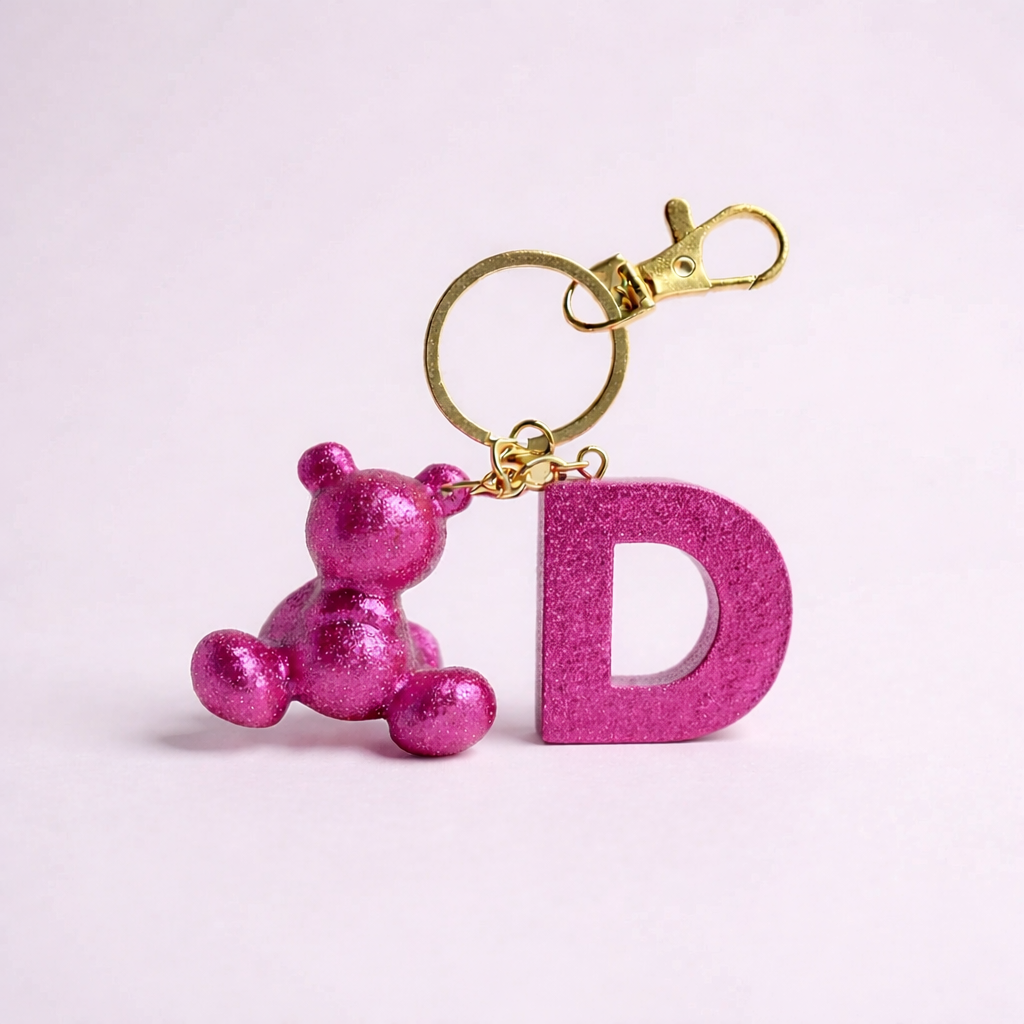 Pink handmade resin bear keychain with the letter D